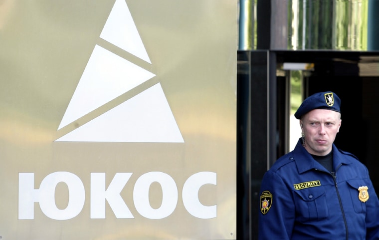 A SECURITY GUARD STANDS OUTSIDE YUKOS HEADQUARTERS IN MOSCOW